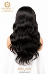 Long, wavy body wave hair in natural black, shown from the back on a model against a white background, with Crowned in Gold branding and text overlays.